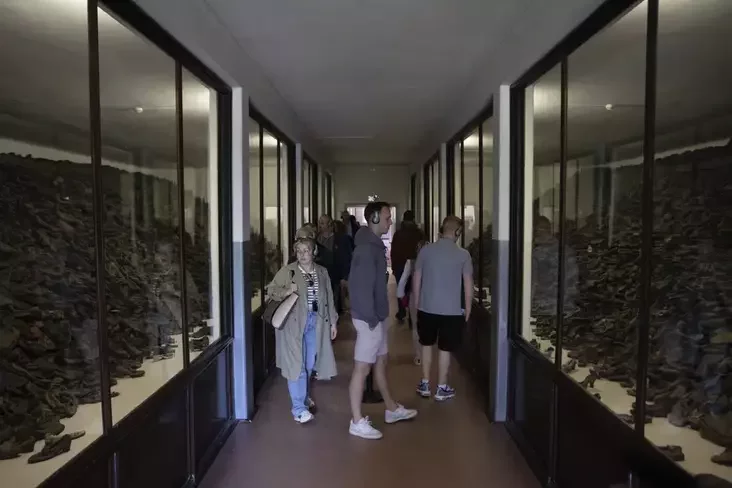 People visit one of the barracks displaying shoes in Oswiecim, Poland